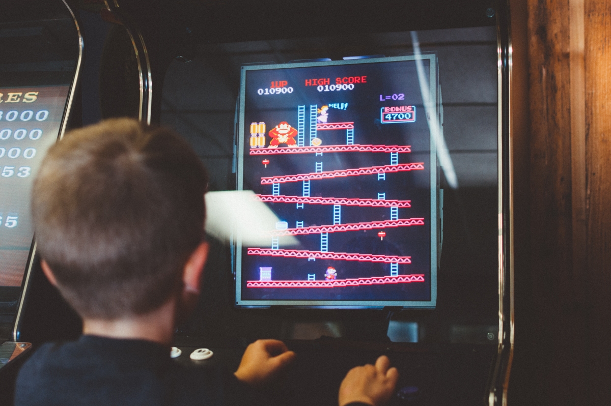 Un enfant jouant au jeu Donkey Kong sur borne d'arcade